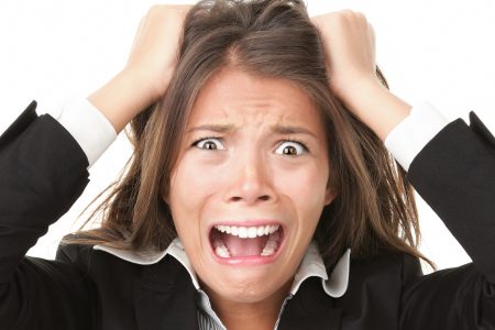 Stress. Woman stressed is going crazy pulling her hair in frustration. Close-up of young businesswoman on white.
